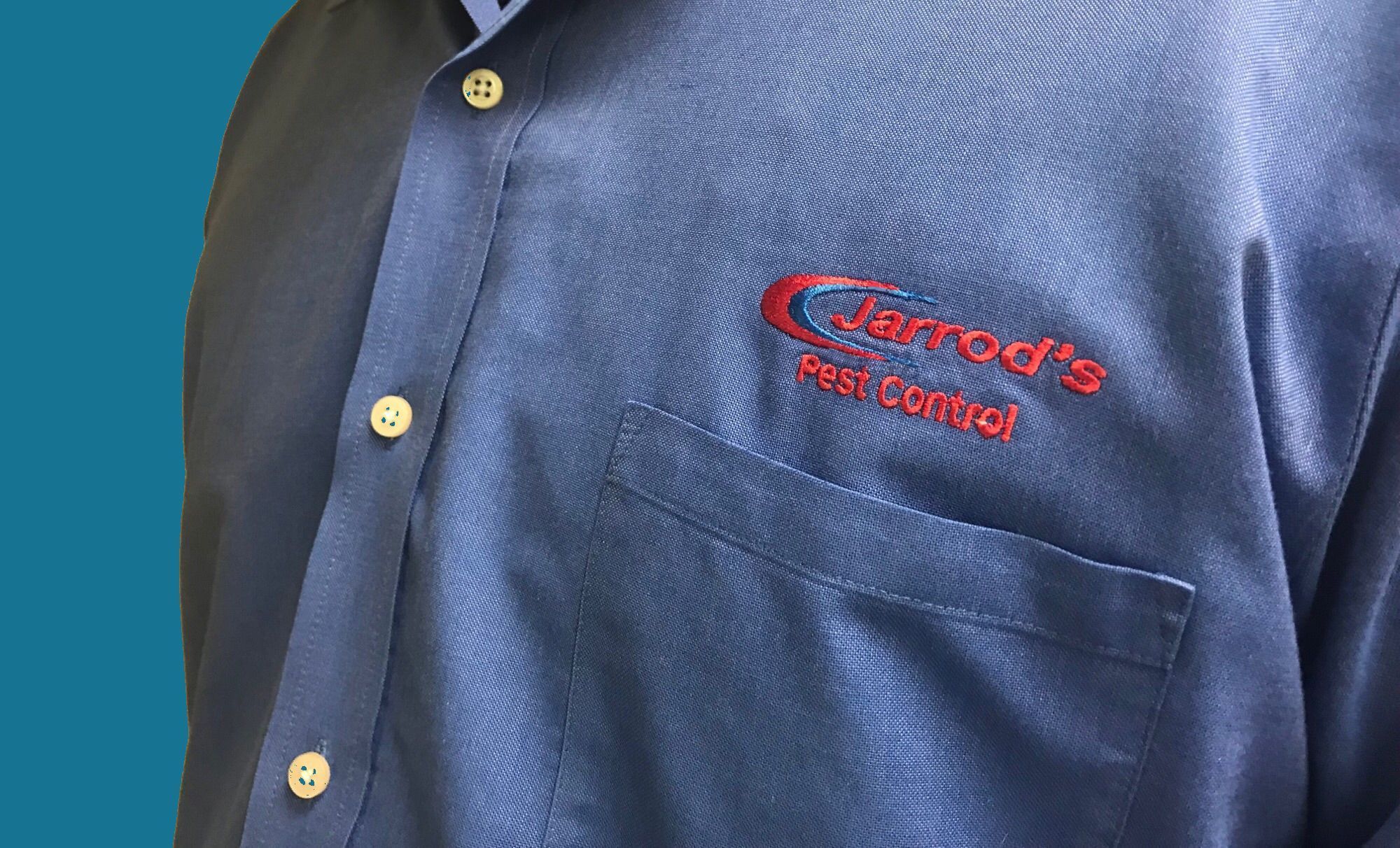 a blue work shirt with the words Jarrod's Pest Control embroidered above the left side pocket